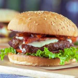 Air Fryer Burger dressed and ready to eat on a cutting board.