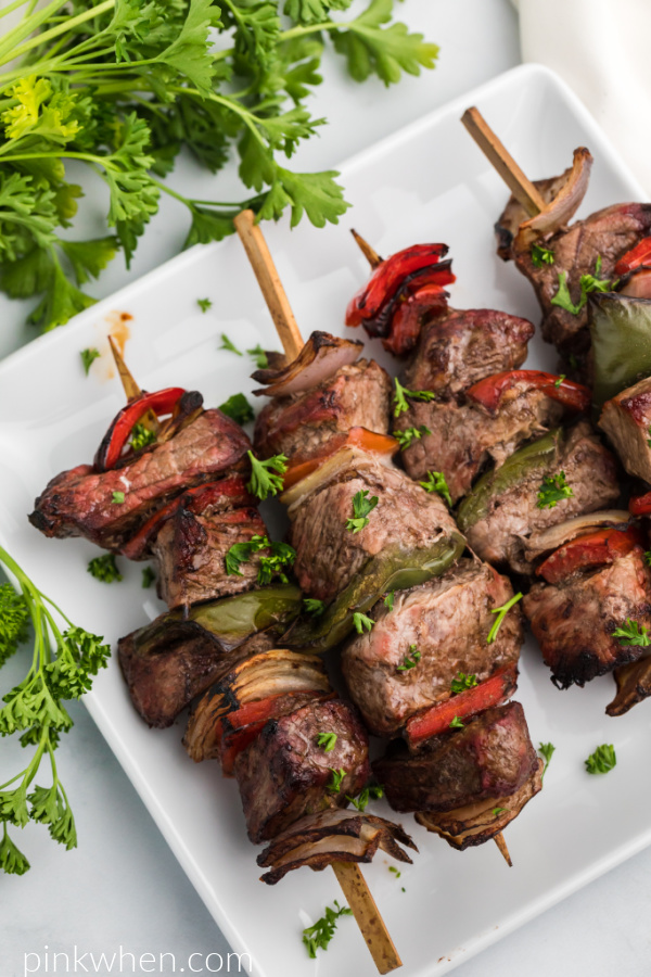 Steak Kabobs on a white plate made with steak, bell peppers, and onion. 