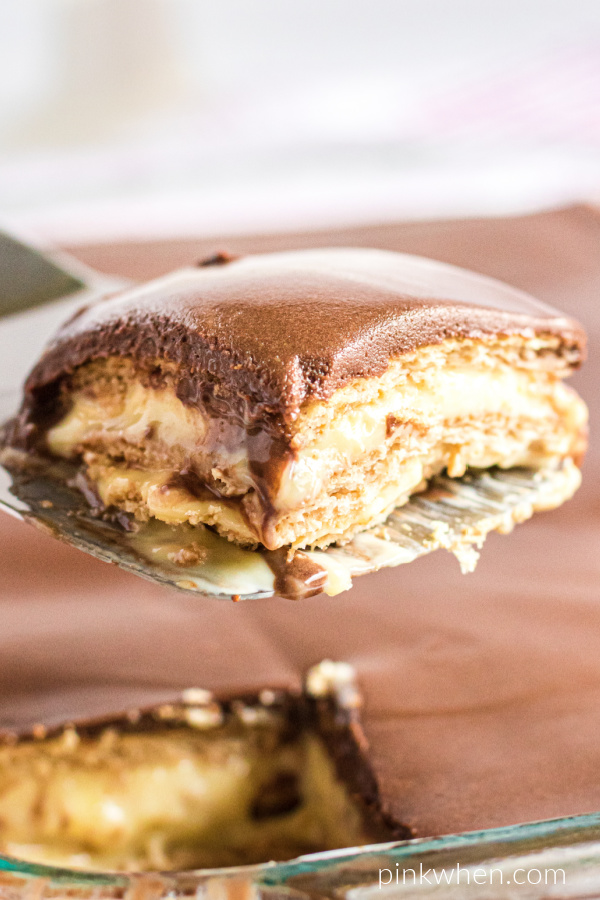Slice of chocolate eclair cake on a spatula ready to serve. 