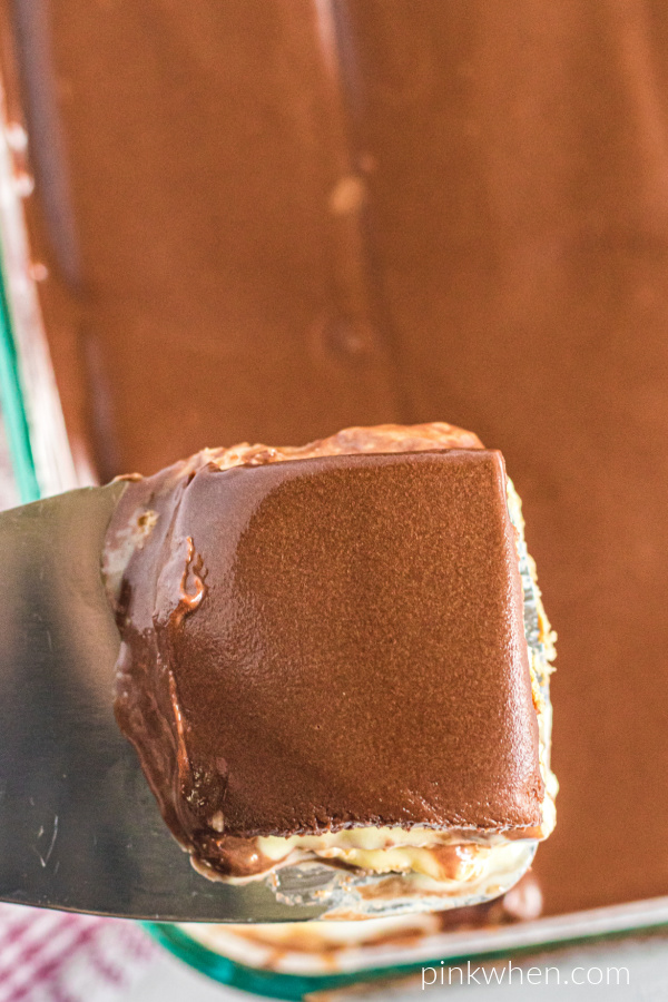 Slice of chocolate eclair cake on a spatula ready to serve. 