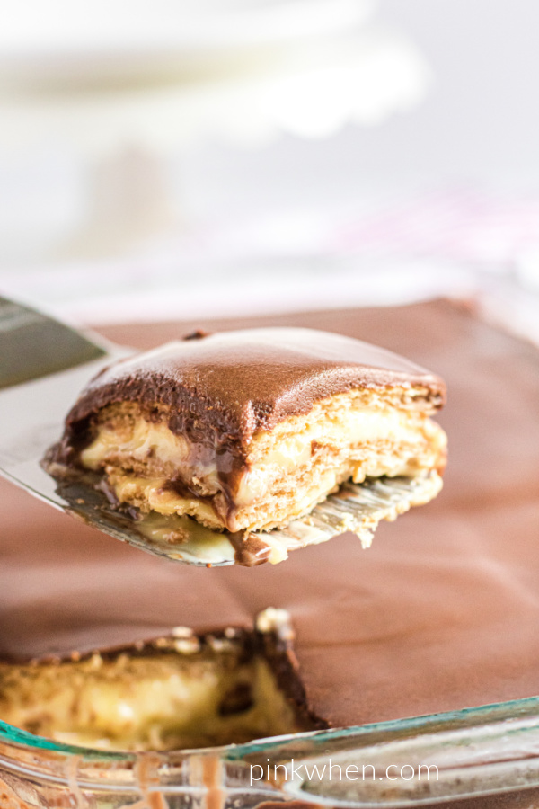 Slice of chocolate eclair cake on a spatula ready to serve. 