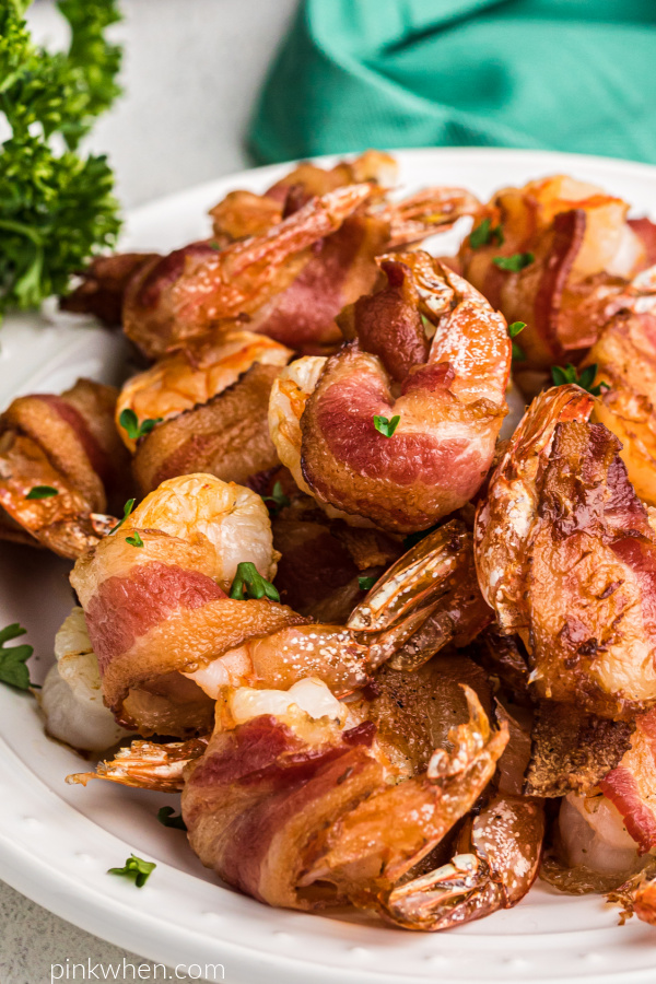 Air Fryer Bacon Wrapped Shrimp on a white plate and garnished with fresh parsley. 