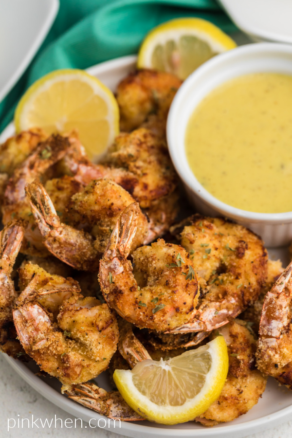 Keto Fried Shrimp made in the air fryer, up close shot of the serving plate with dipping sauce and lemon wedges. 