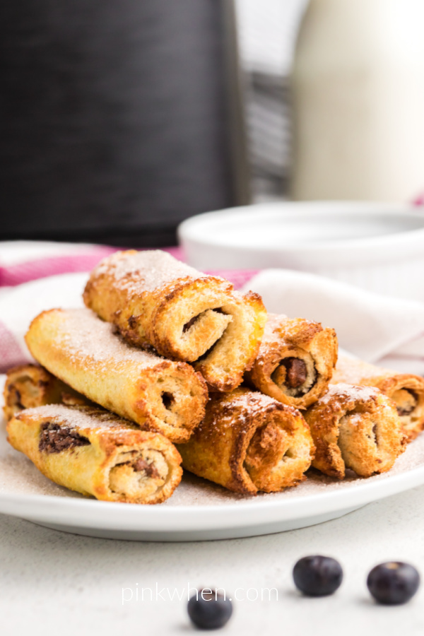 Nutella French Toast Roll Ups made in the air fryer on a white plate ready to serve. 