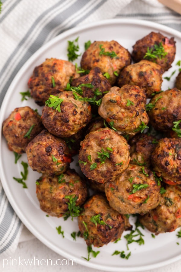 Air Fryer Turkey Meatballs on a white plate garnished with fresh parsley. 