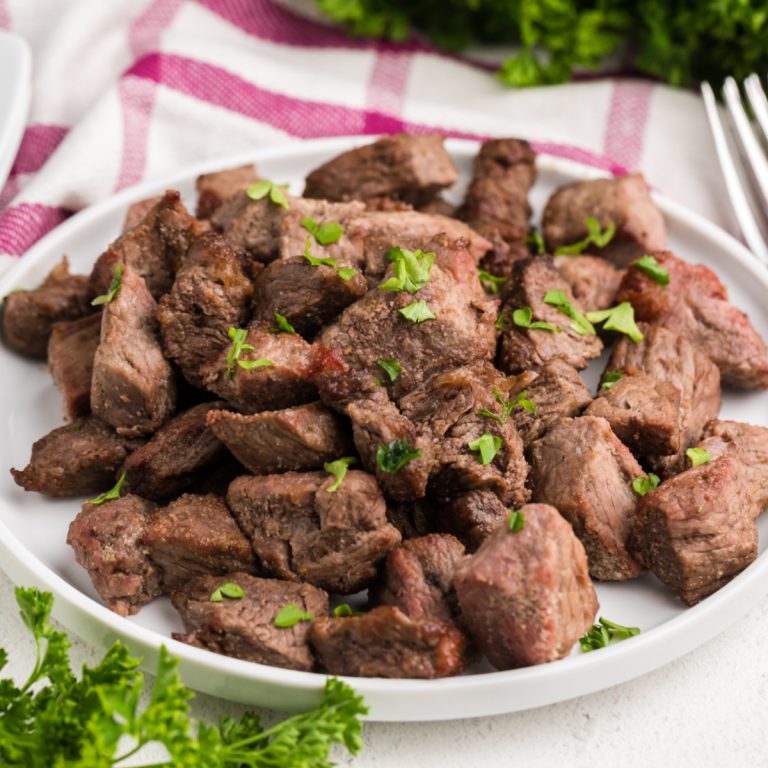 Garlic Butter Steak bites made in the air fryer and served on a white plate.