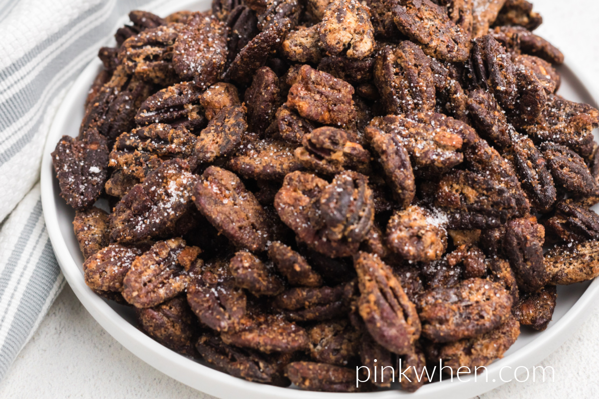 Air Fryer Candied Pecans on a white plate ready to eat. 