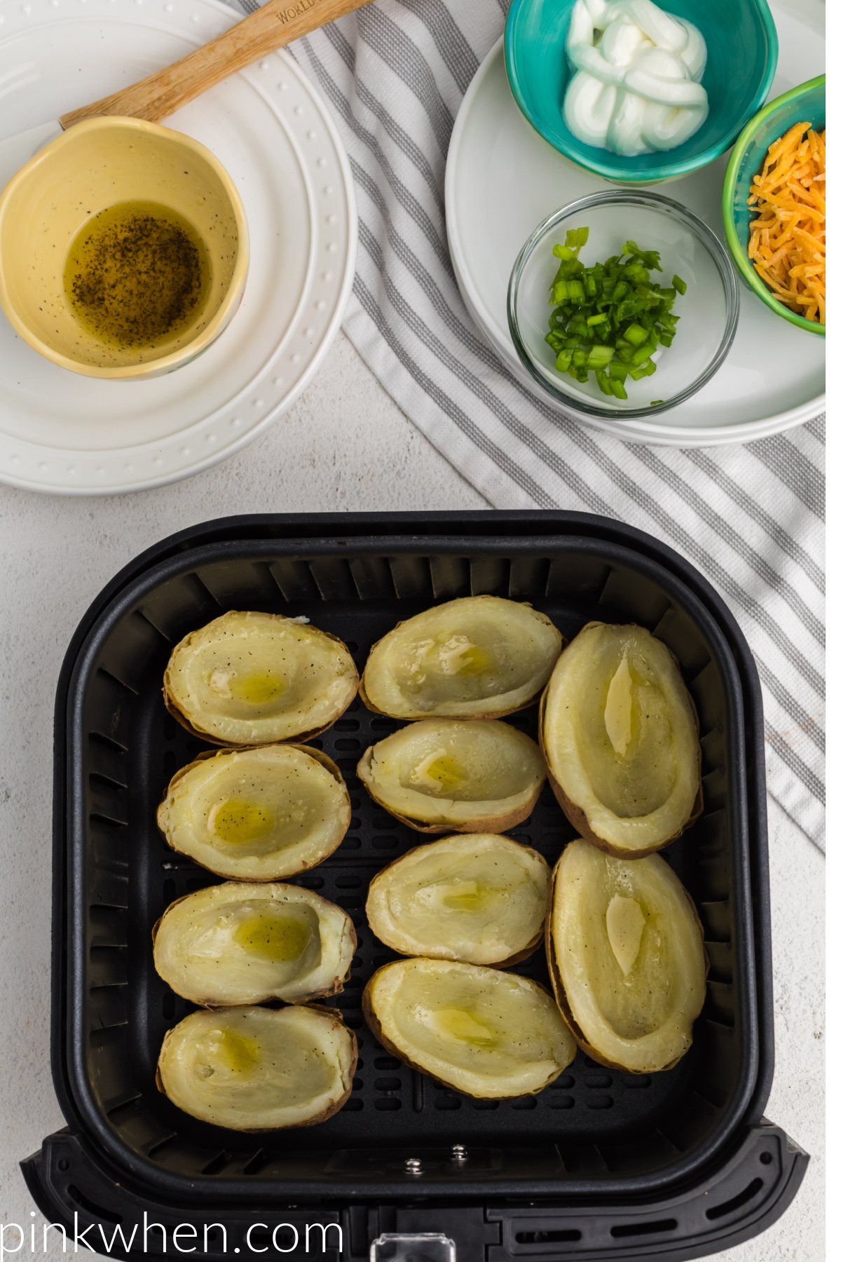 Potato skins brushed with salt, pepper, and olive oil and placed skin side down into the air fryer basket. 