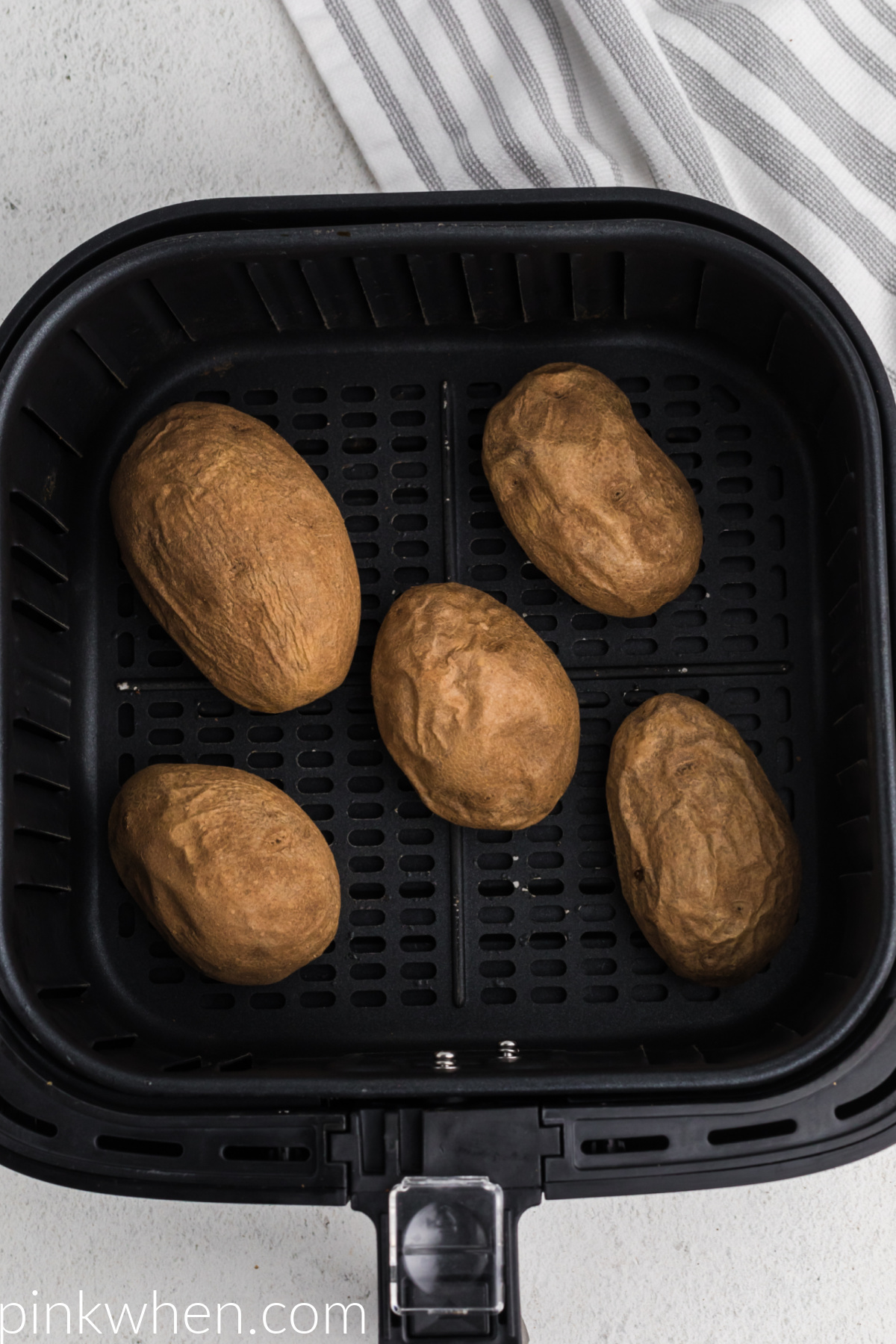 Cooked potatoes in the basket of the air fryer 