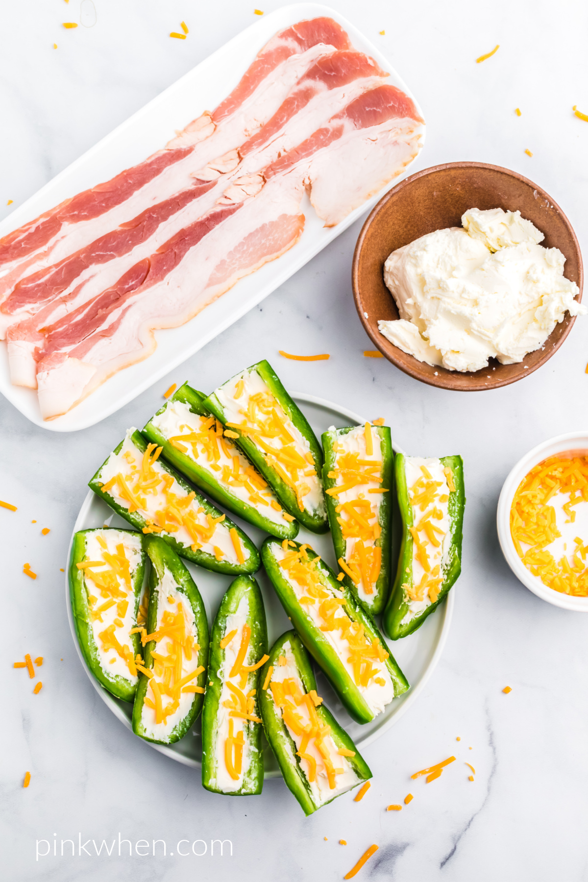 Jalapeno peppers cut lengthwise and stuffed with cream cheese and topped with cheddar cheese. 