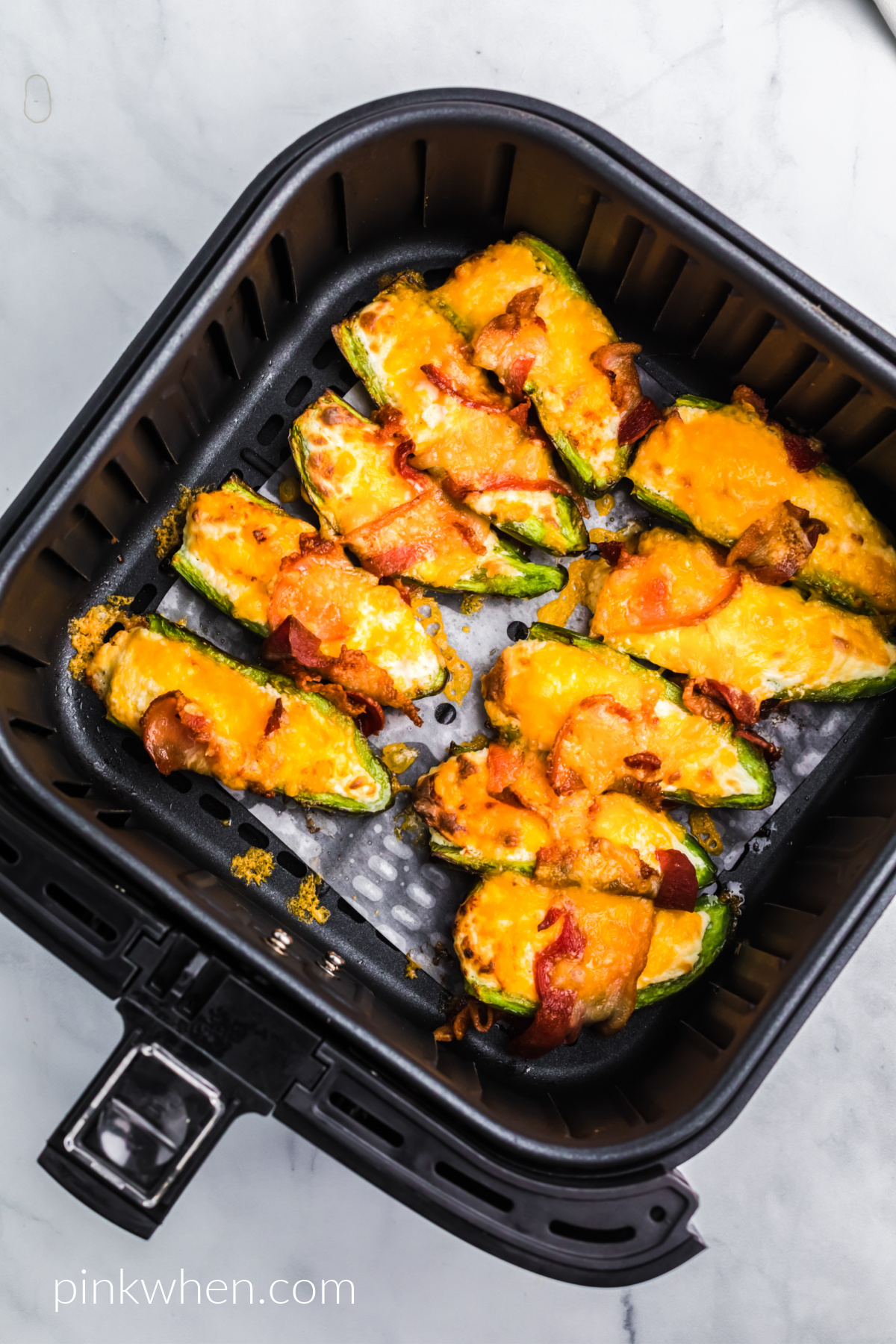 air fried jalapeno poppers in the basket of the air fryer. 