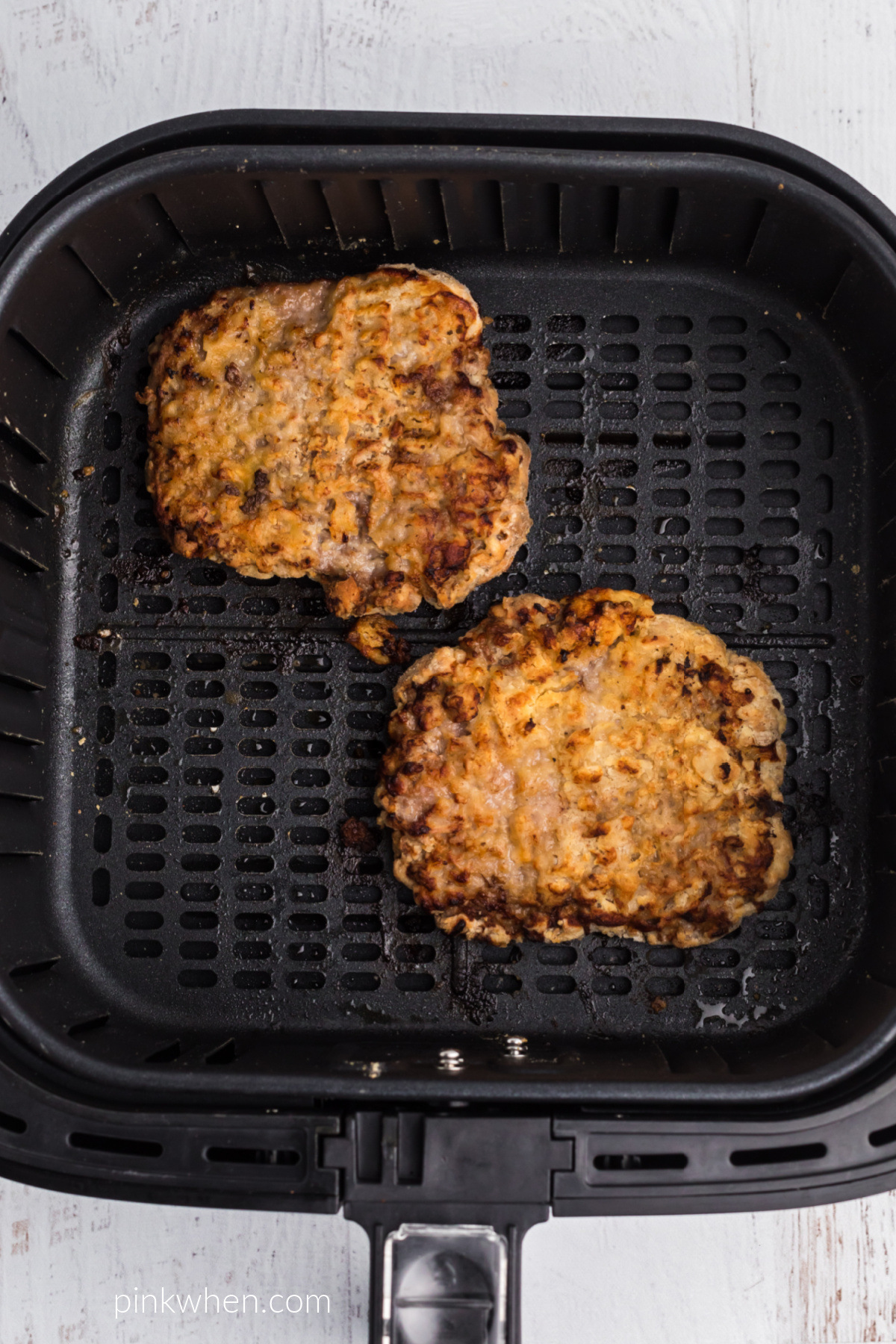 Chicken Fried Steaks fully cooked in the basket of the air fryer. 