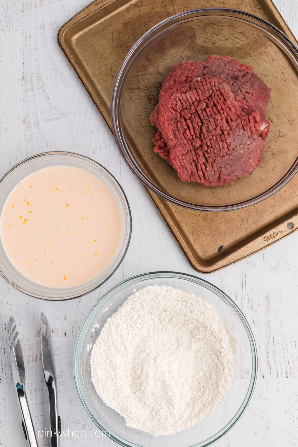 Flour mixture, egg mixture, and cubed steaks ready to make chicken fried steak.