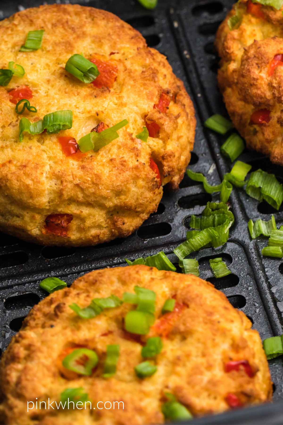 Close up photo of cooked crab cakes in the air fryer basket.