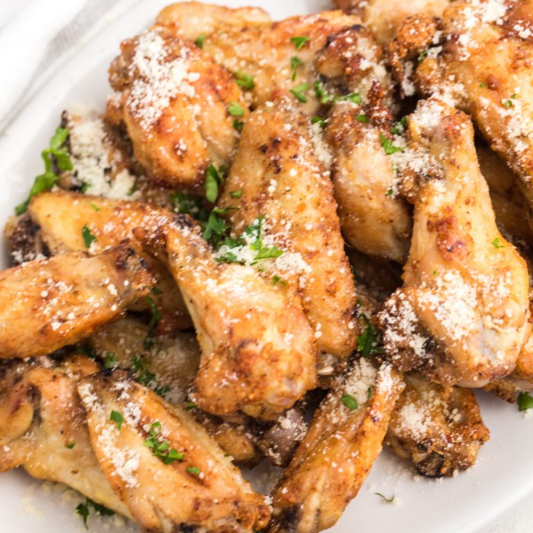 Air Fryer Garlic Parmesan Chicken Wings garnished with fresh parsley and parmesan cheese.