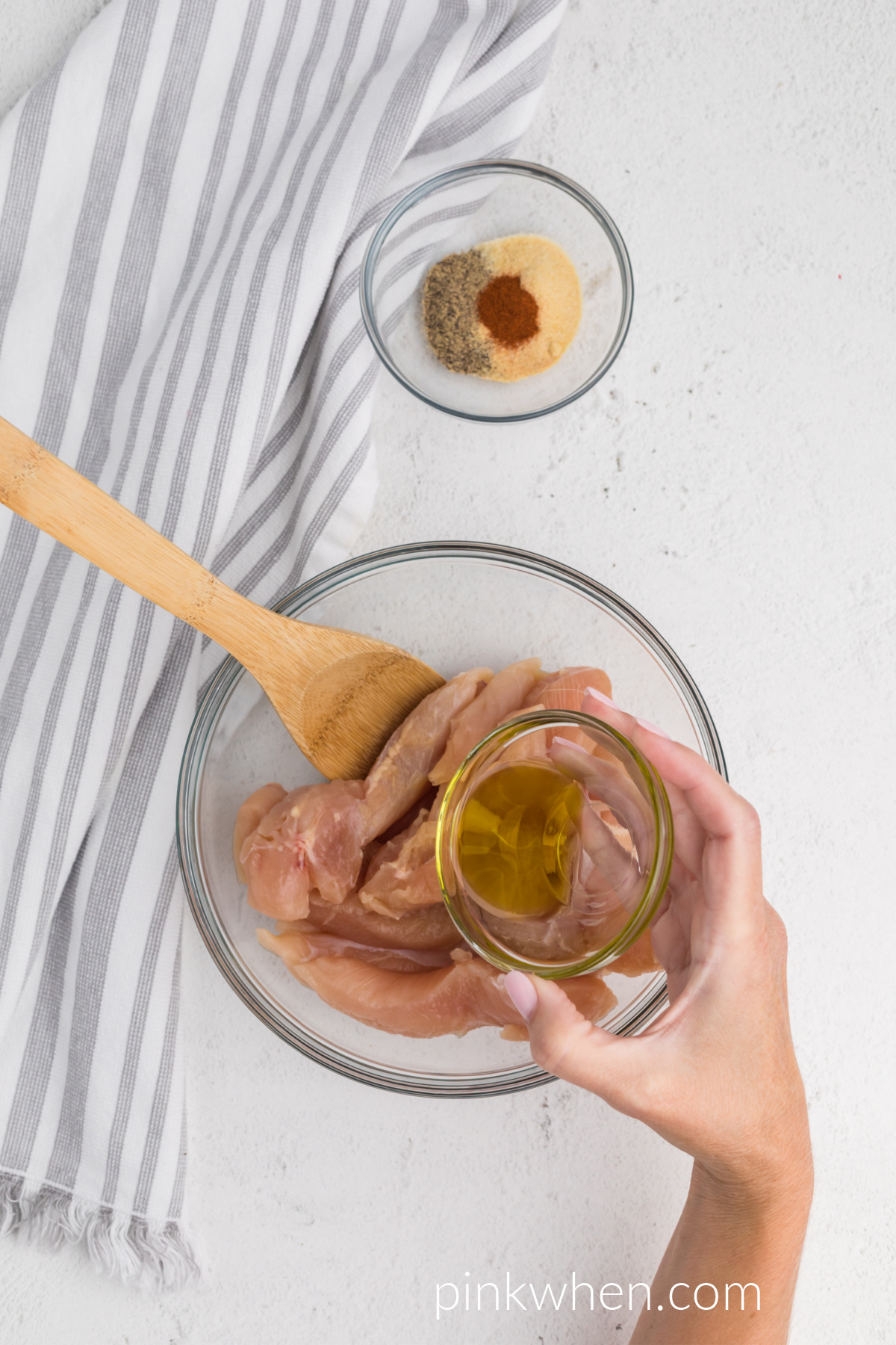 a dish with olive oil to be added to chicken tenders in a mixing bowl. 