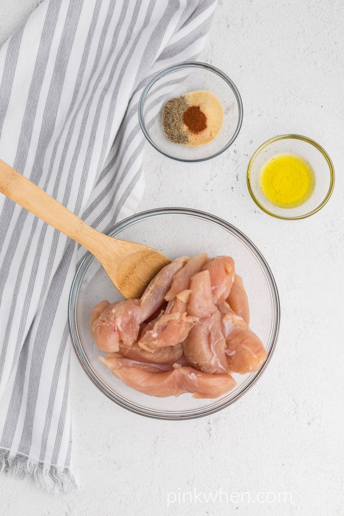 Chicken tenders in a mixing bowl.