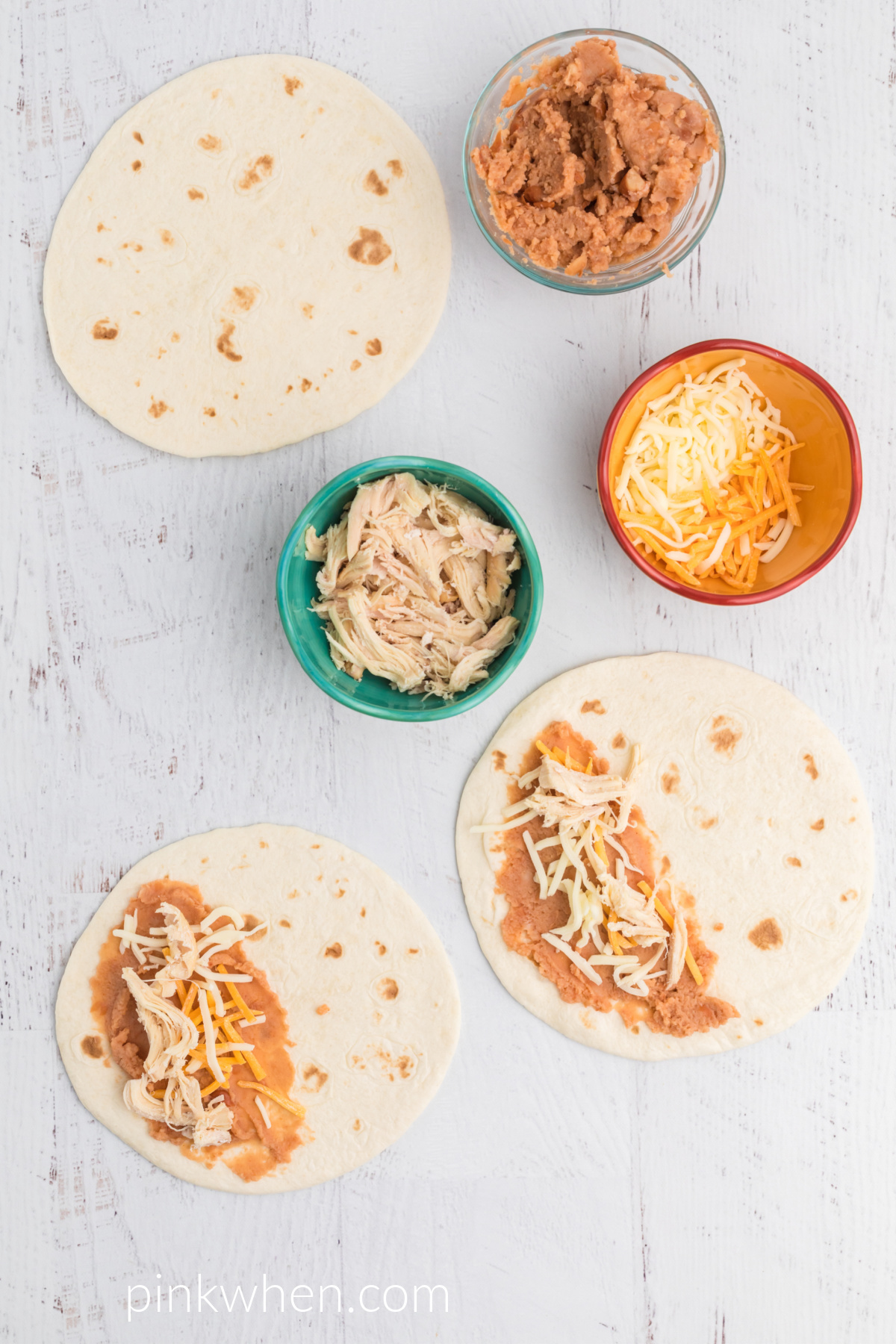 Tortillas with refried beans and shredded cheese on top. 