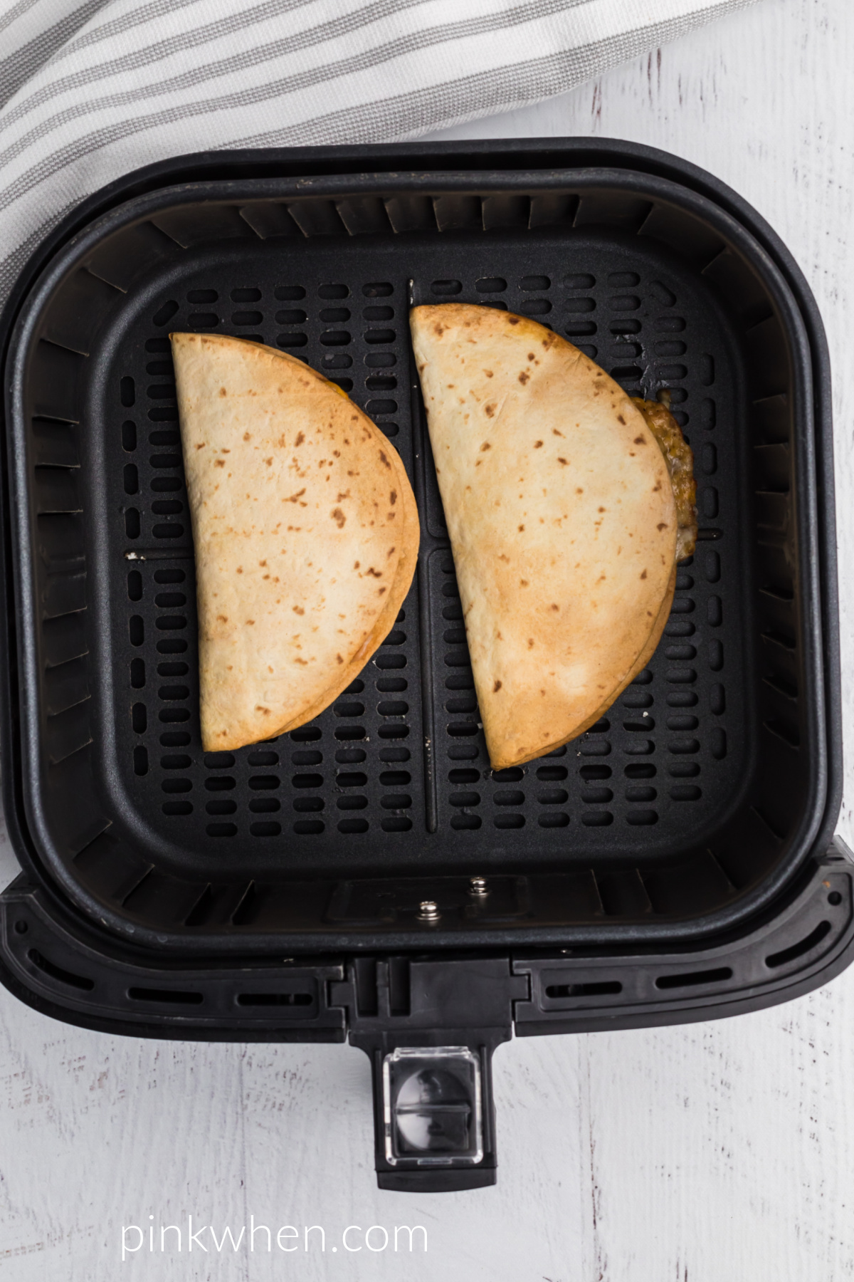 Cooked quesadillas in the air fryer basket. 