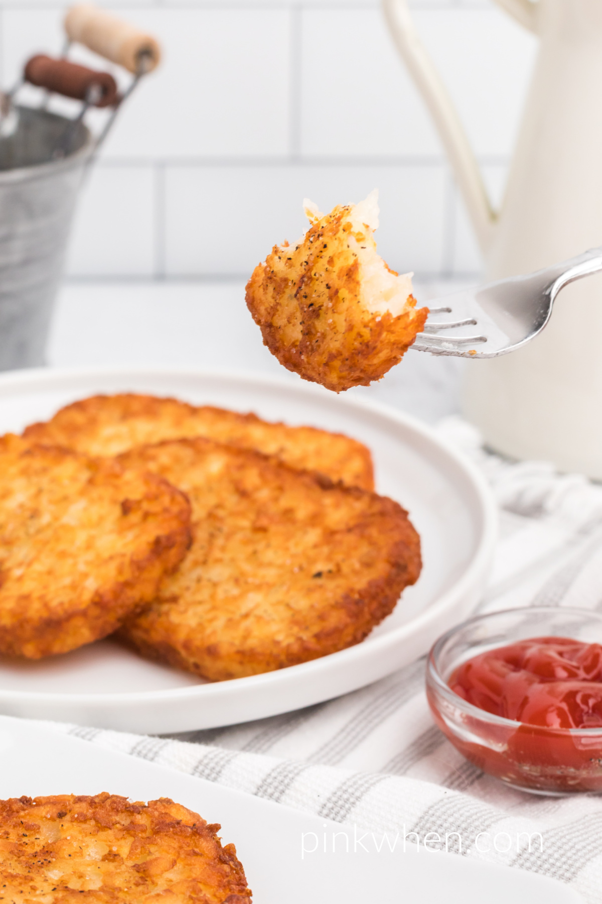 Frozen Hash Brown Patties that were made in the air fryer, with a bite of has brown on a fork. 