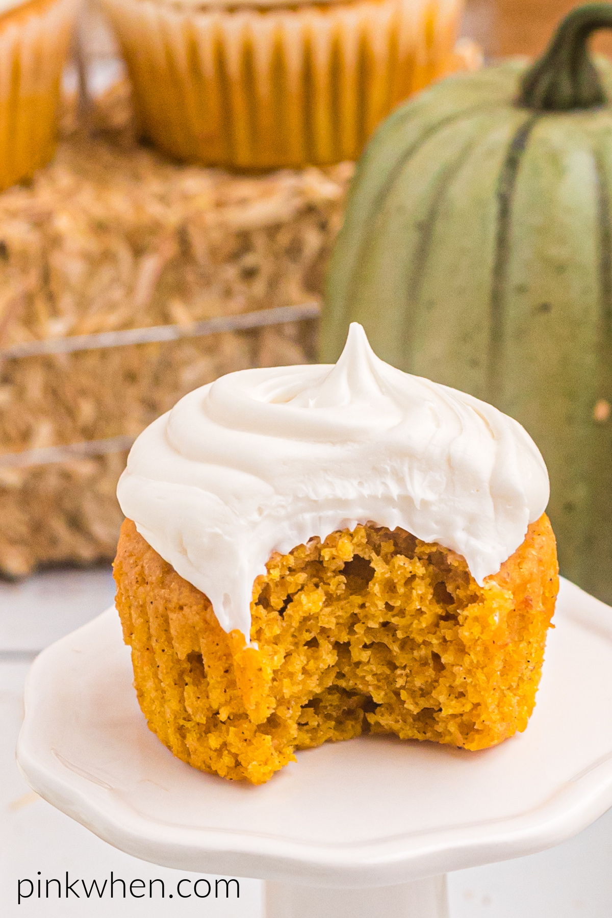 Bite taken out of a pumpkin spice cupcake. 
