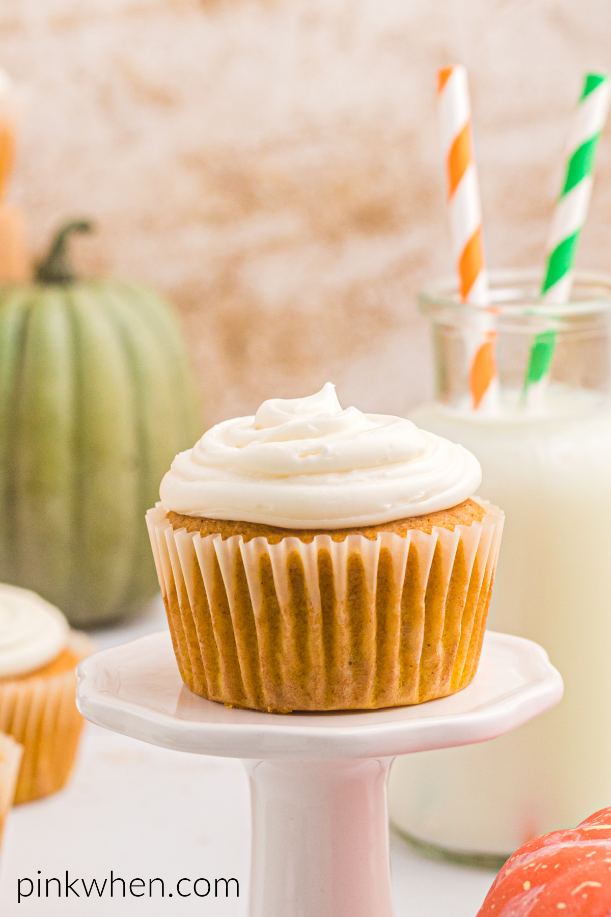 Pumpkin Spice Cupcake on a small pedestal ready to eat. 