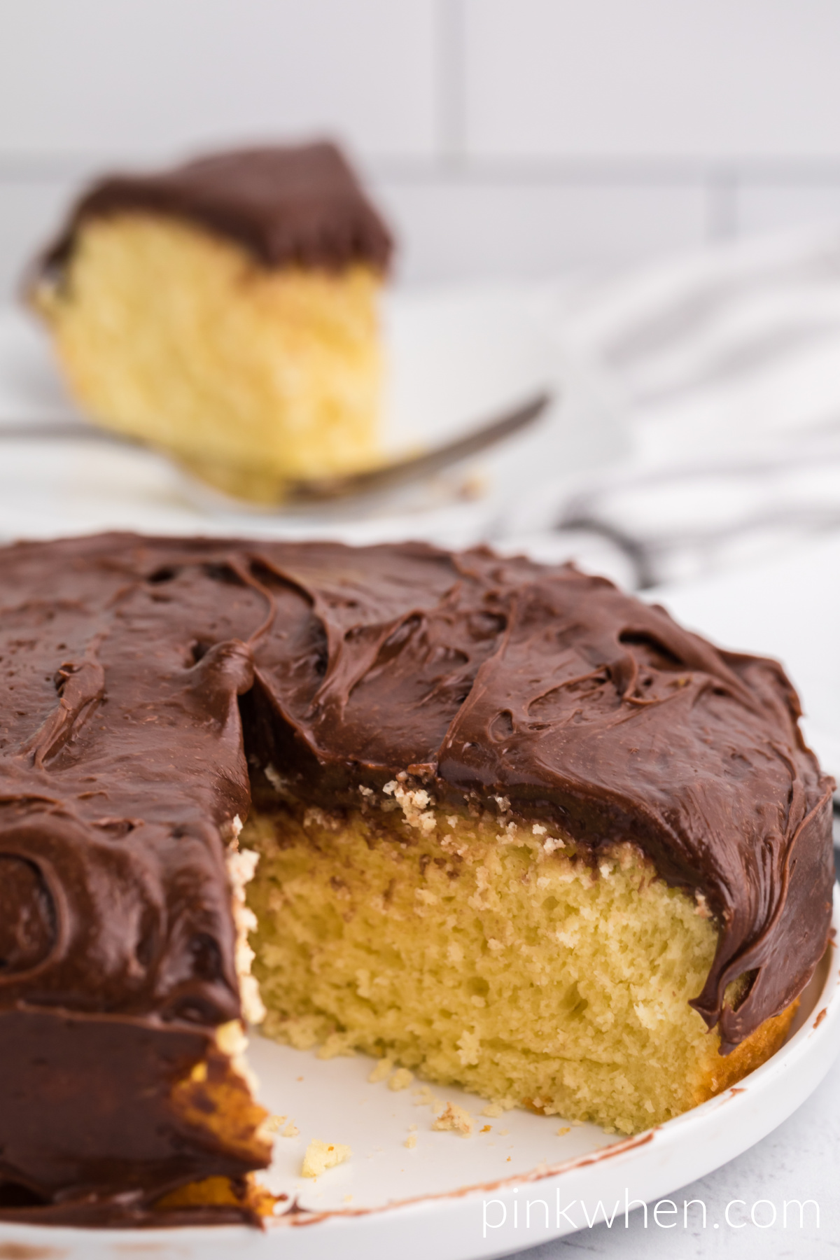 Showing the inside of a cut boxed air fryer cake with chocolate frosting on top. 