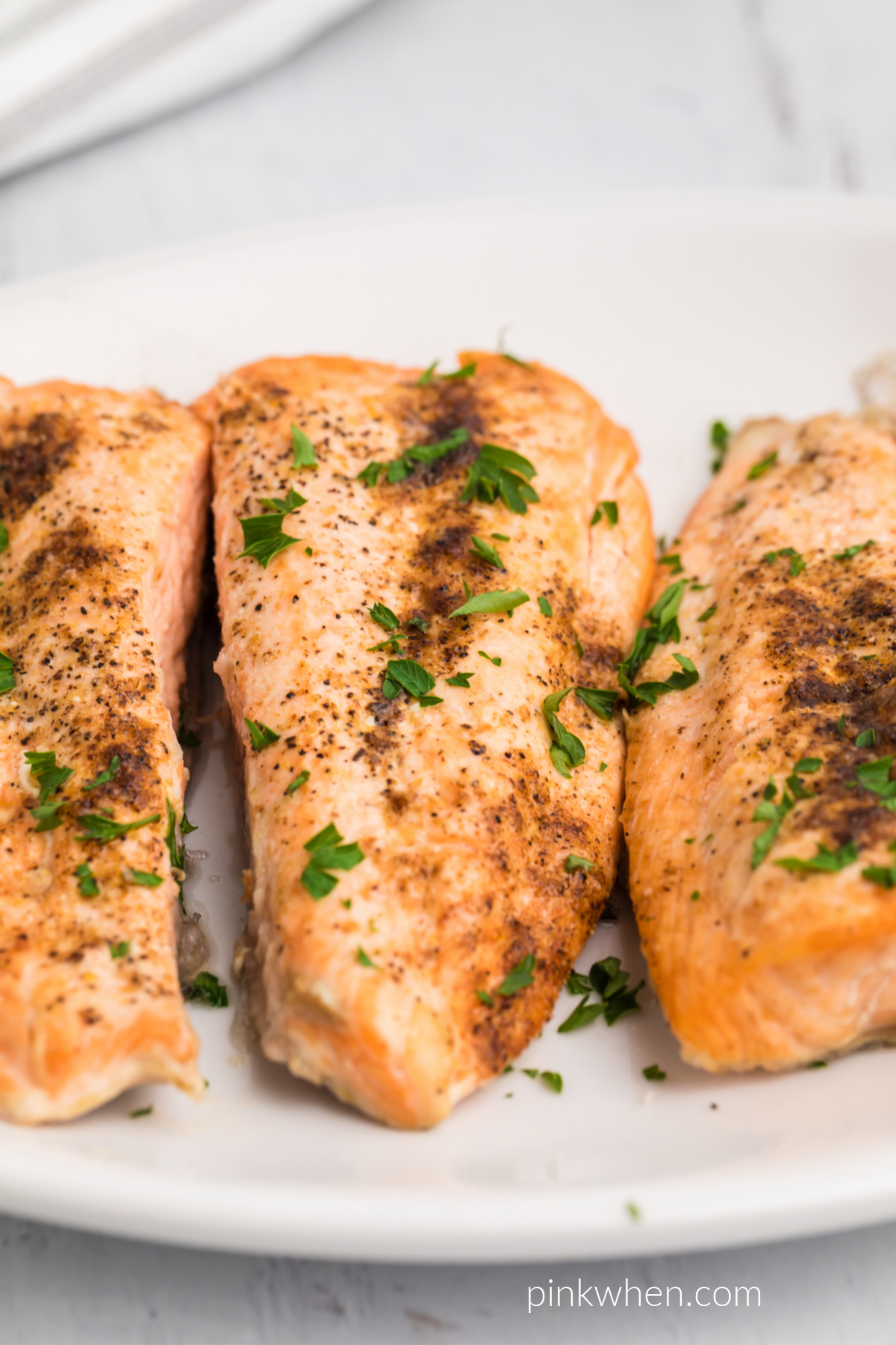 Air Fryer Salmon topped with fresh parsley and ready to eat. 