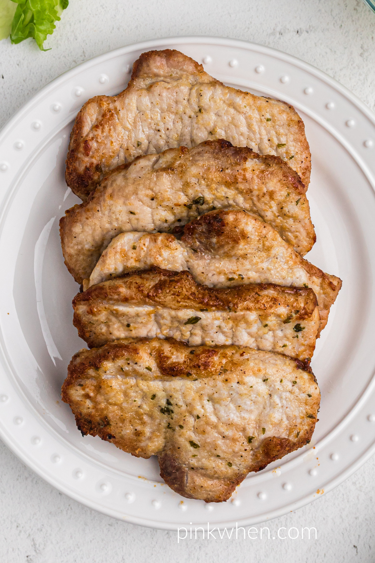 Pork chops on a plate seasoned and ready to serve that were made in the air fryer without breading.