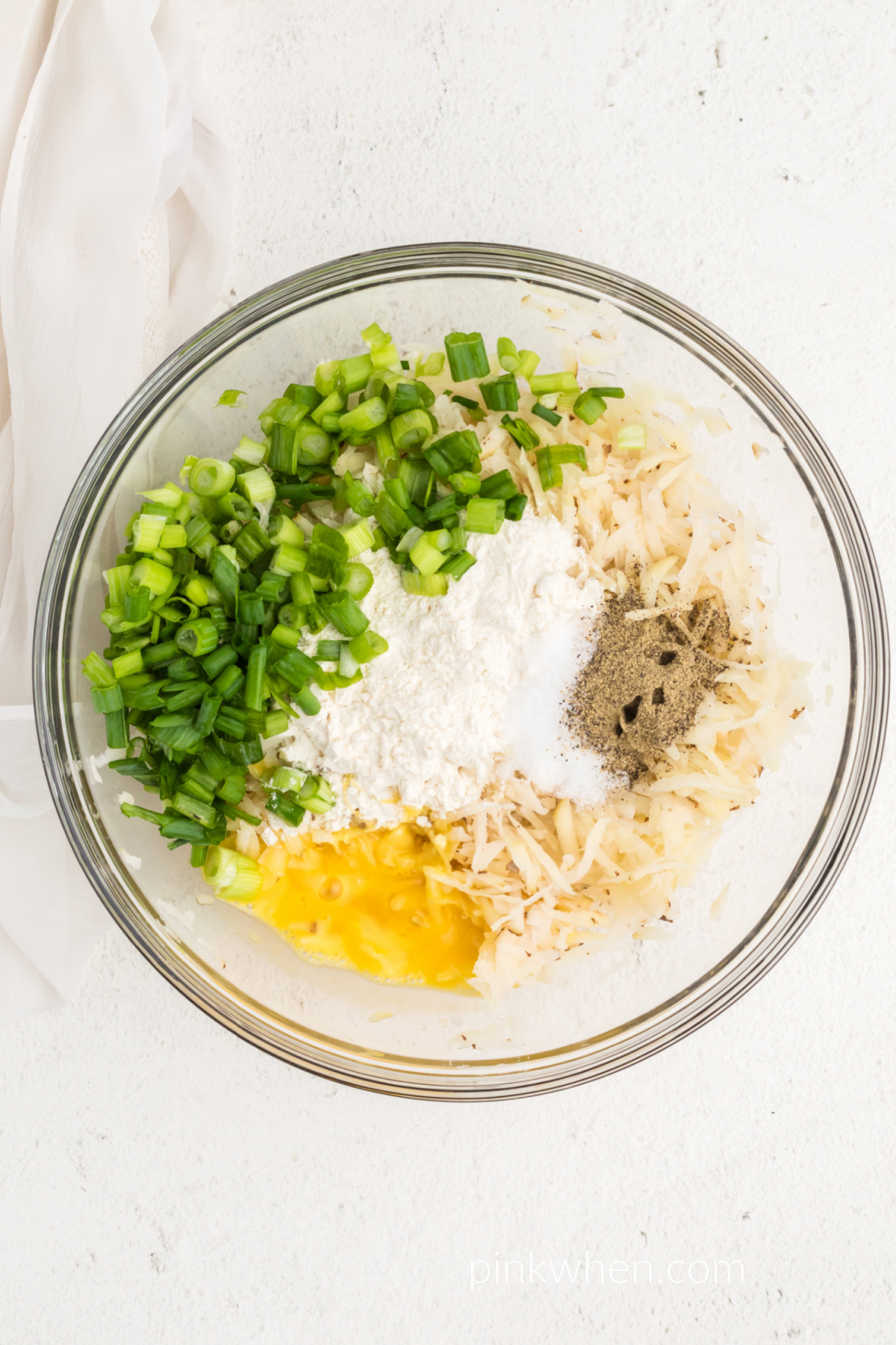 Mix of ingredients in a bowl to make potato fritters in the air fryer. 