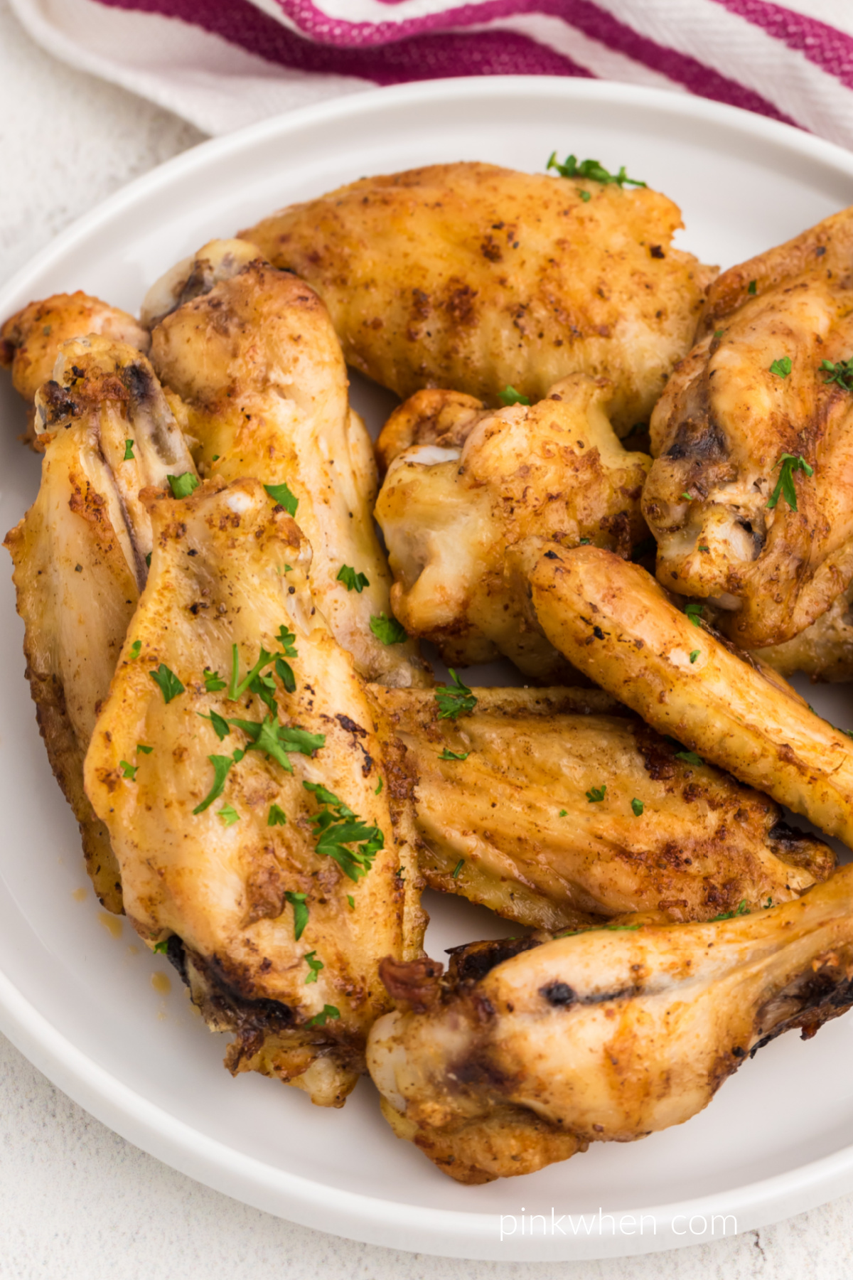 Seasoned chicken wings made from frozen in the air fryer and garnished with fresh parsley. 