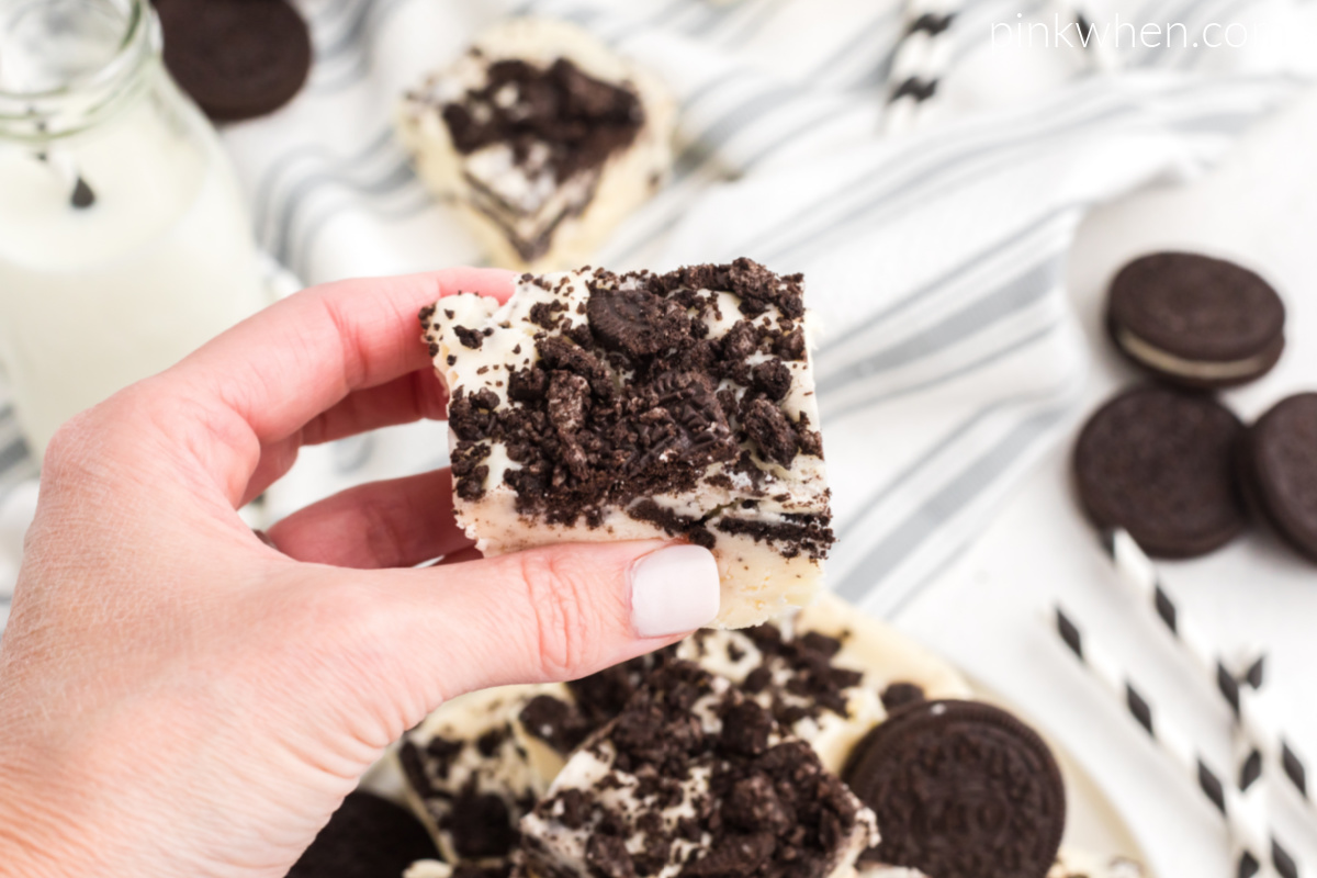 Hand holding a piece of OREO cookie fudge ready to eat. 