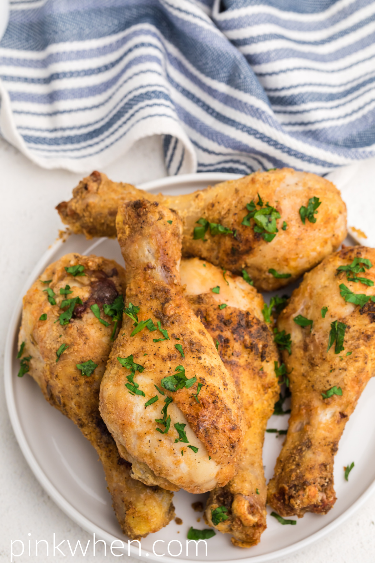 Air Fryer Chicken Drumsticks seasoned and cooked and served on a white plate.