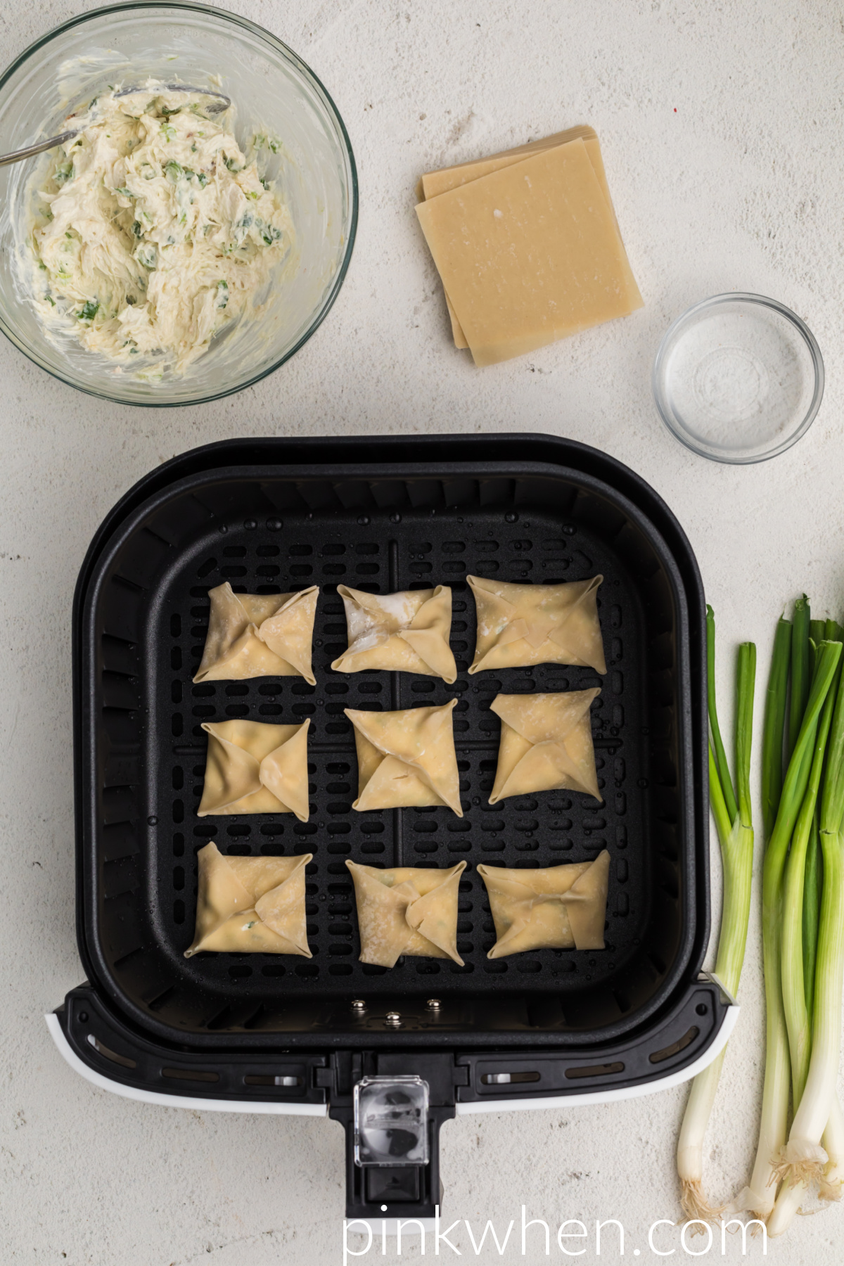 Basket full of crab rangoon ready to be cooked in the air fryer. 