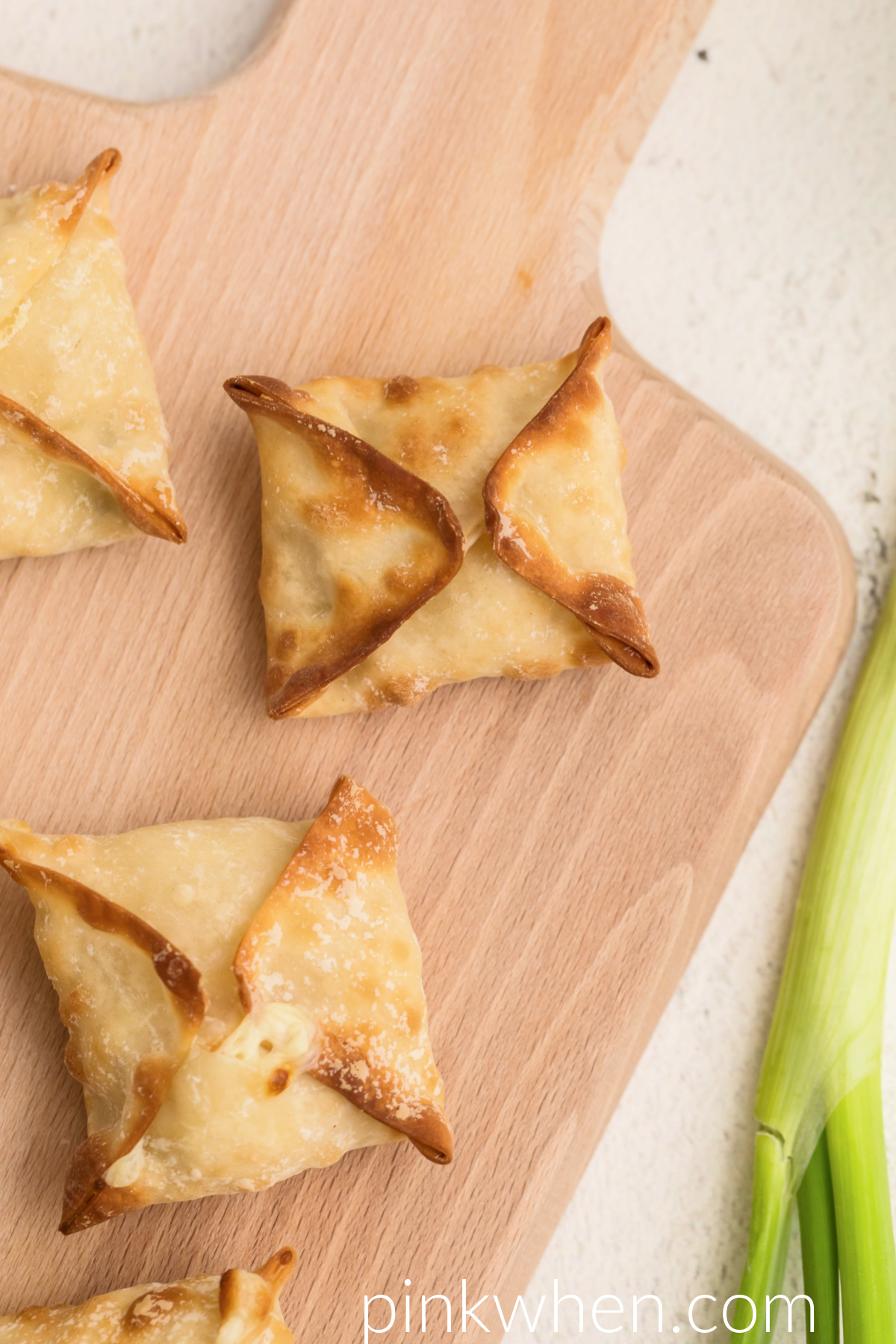 Close up of homemade air fryer crab rangoon on a serving board ready to eat. 
