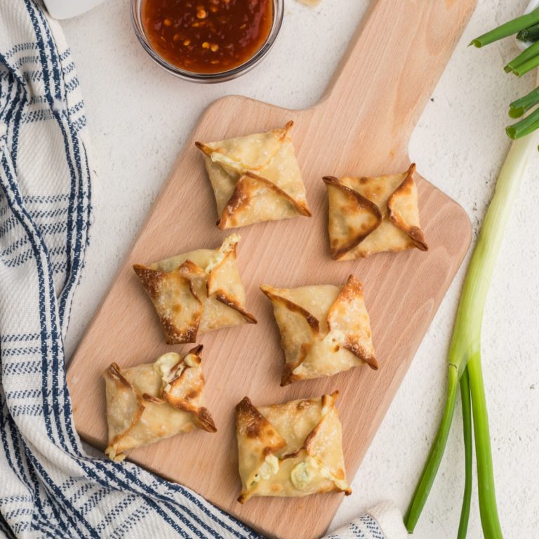Oveerhead shot of crab rangoon on a cutting board ready to serve.