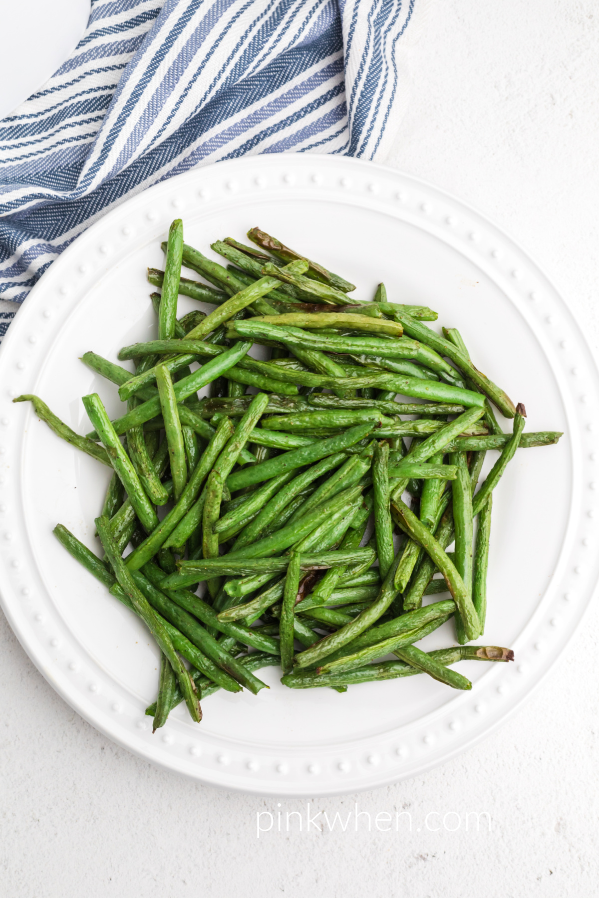 air fried green beans recipe on a white plate ready to serve.
