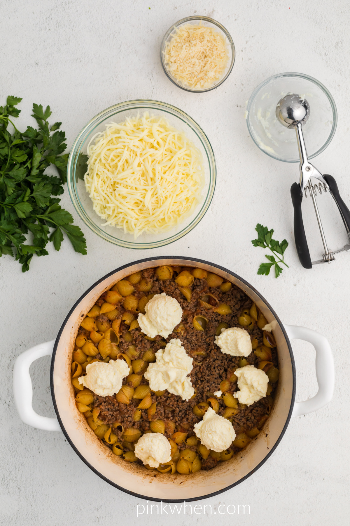 One pot lasagna with cooked beef and pasta shells stirred in with drops of ricotta cheese on top.