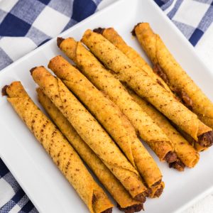 Overhead shot of air fried taquitos on a white plate.