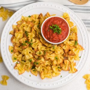 Overhead shot of pasta chips made in the air fryer and served on a white plate.