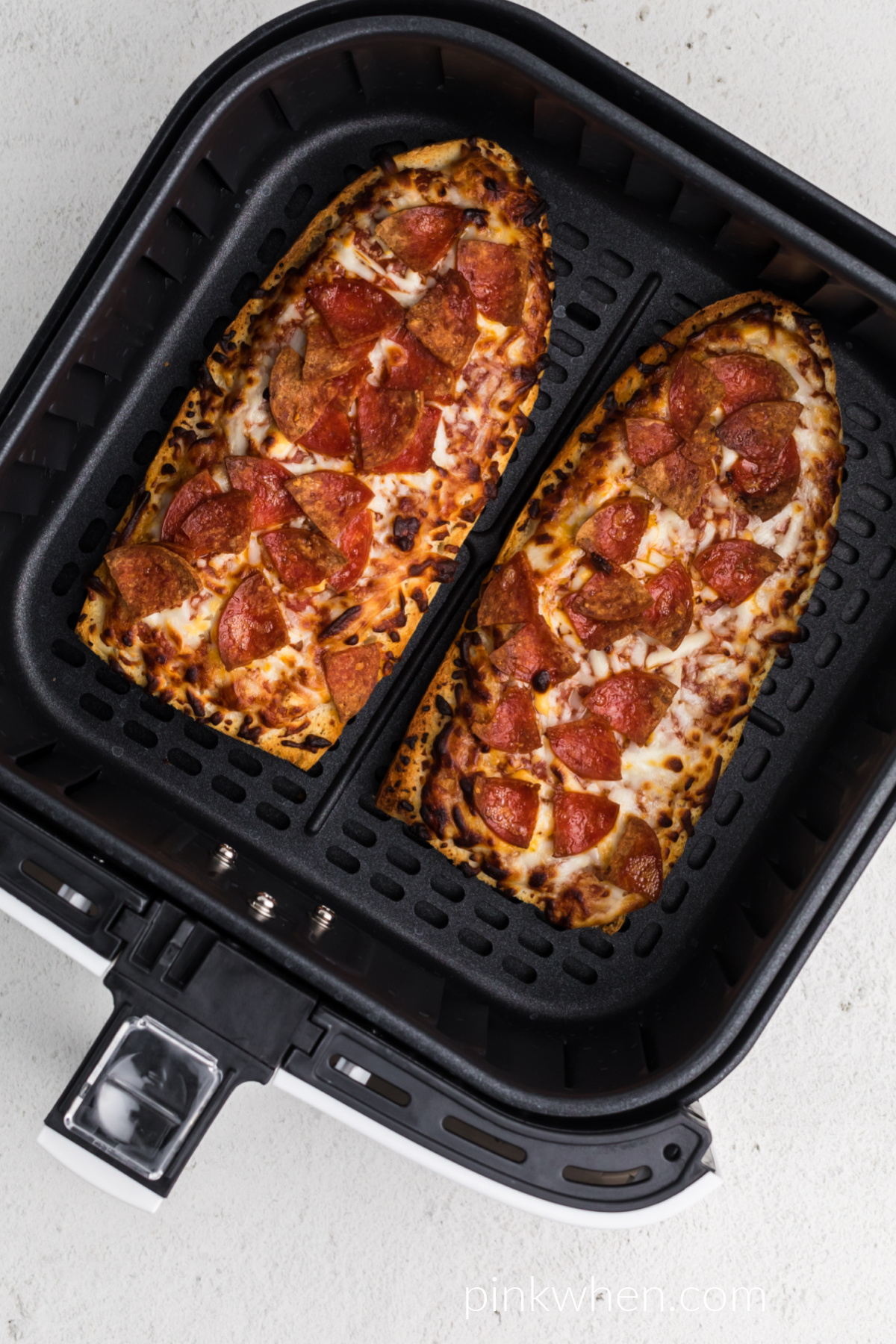 Cooked from frozen french bread pizzas in the basket of the air fryer. 
