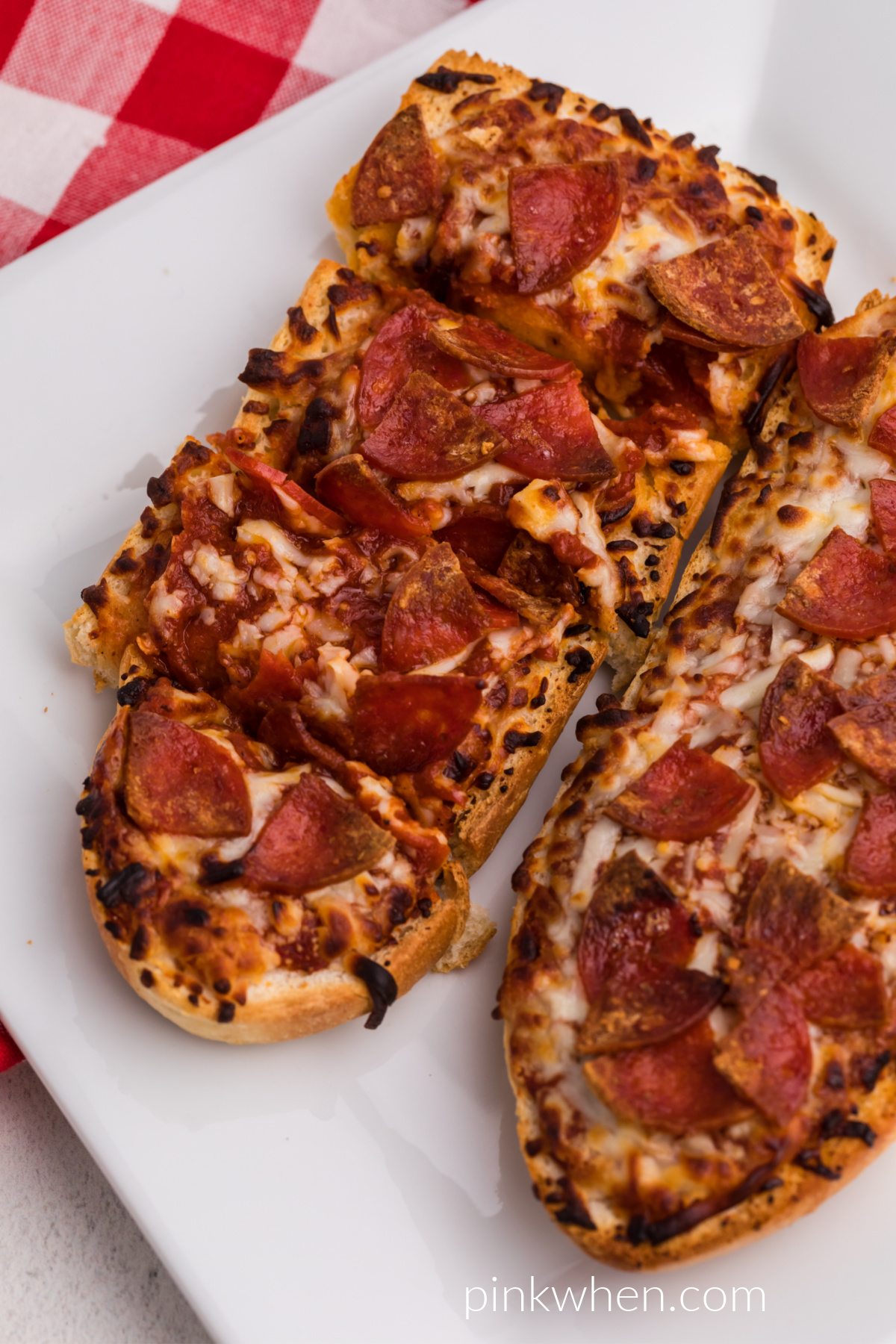 French bread pizza made in the air fryer and served on a white plate. 