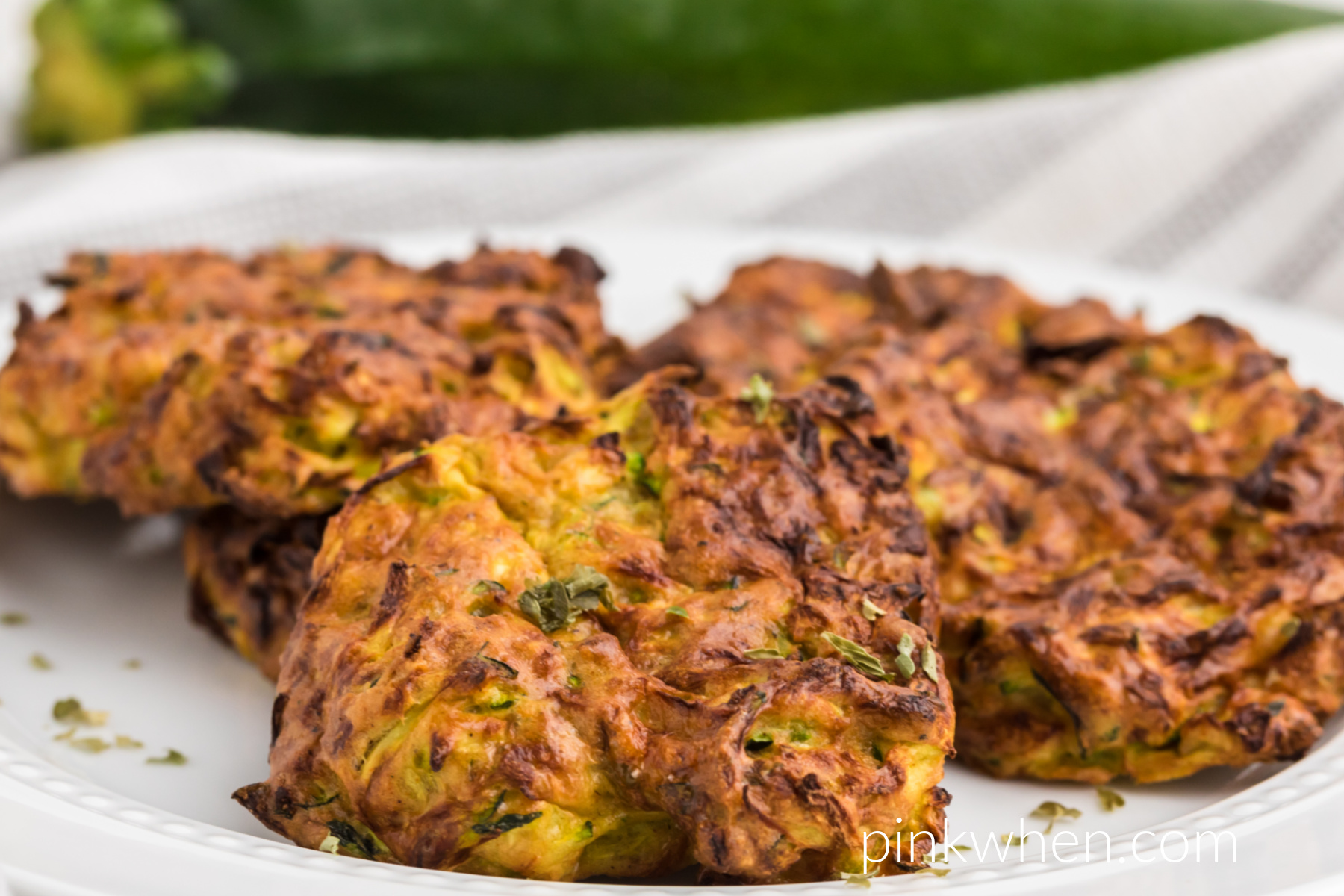 zucchini fritters on a whit eplate ready to serve. 