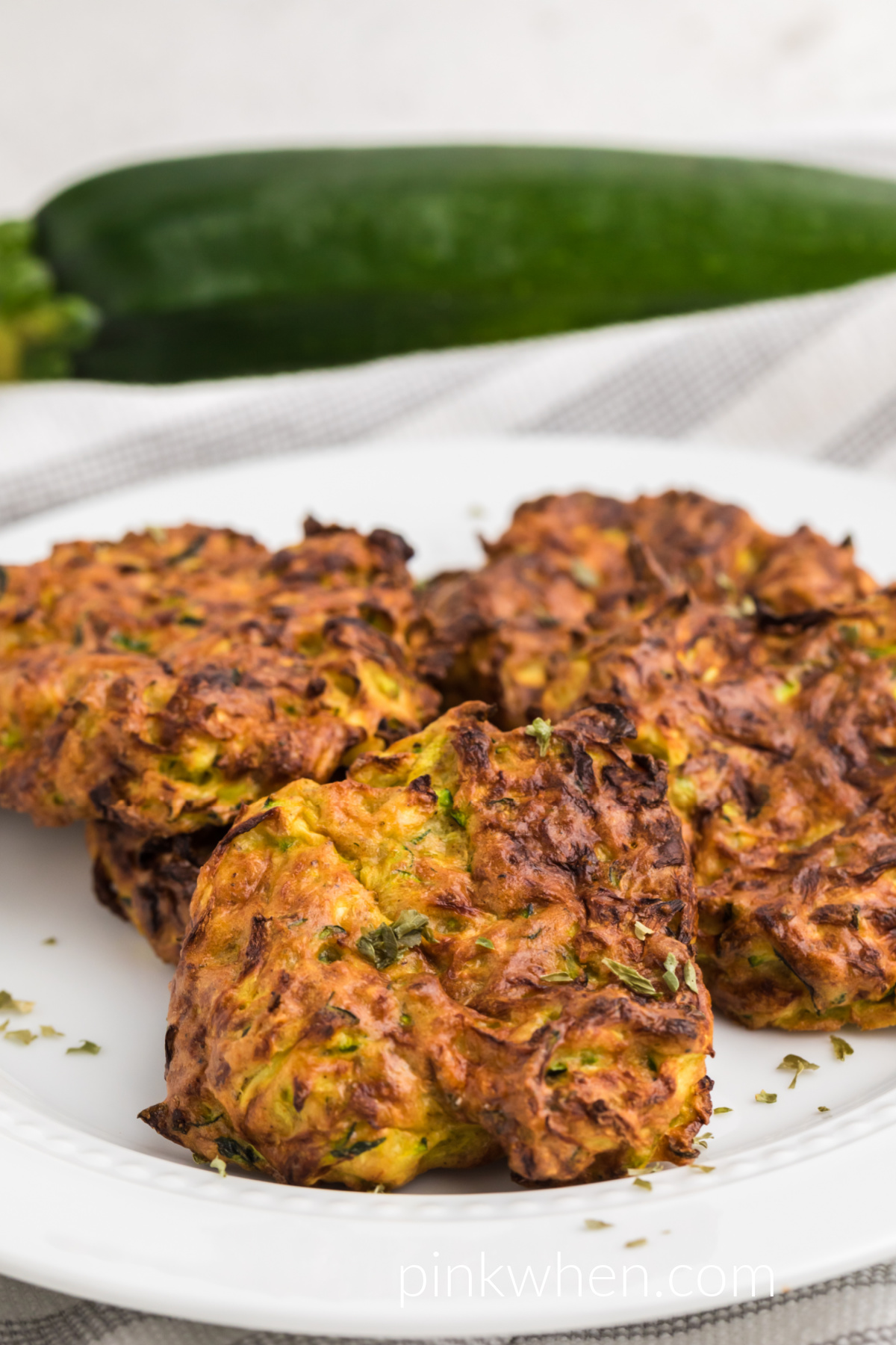Air fried zucchini fritters on a white plate. 