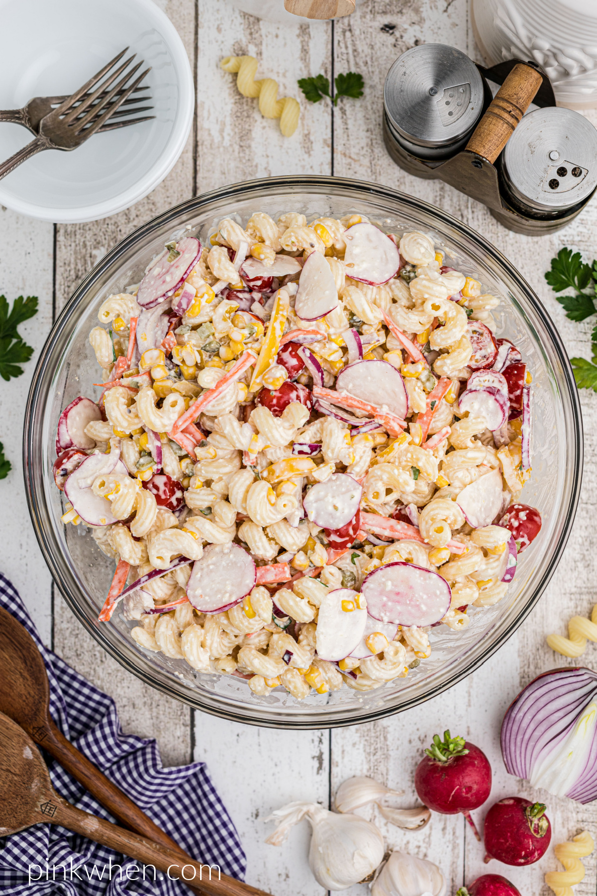Overhead shot of pasta salad on a table, ready to serve.