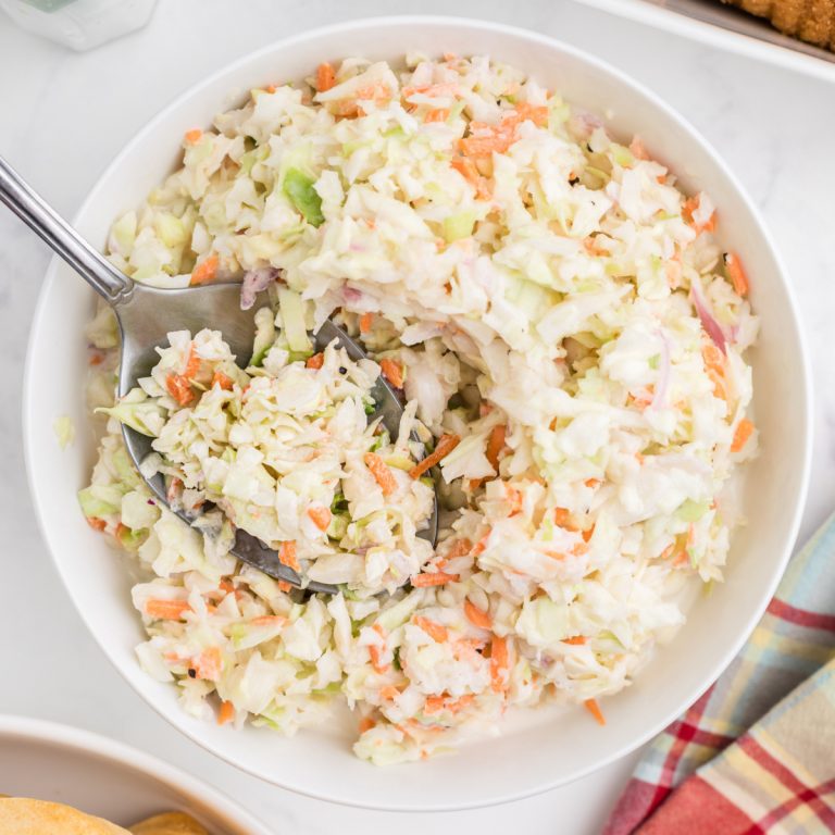 Overhead photo of copycat KFC coleslaw with a serving spoon.