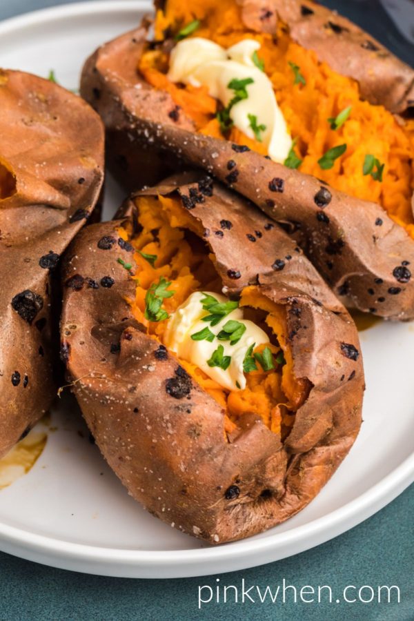 Bright orange sweet potatoes baked and topped with melted butter and parsley flakes. 