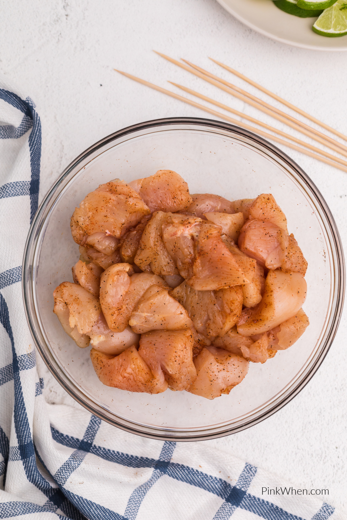 Cut chicken tossed in seasonings in a bowl.