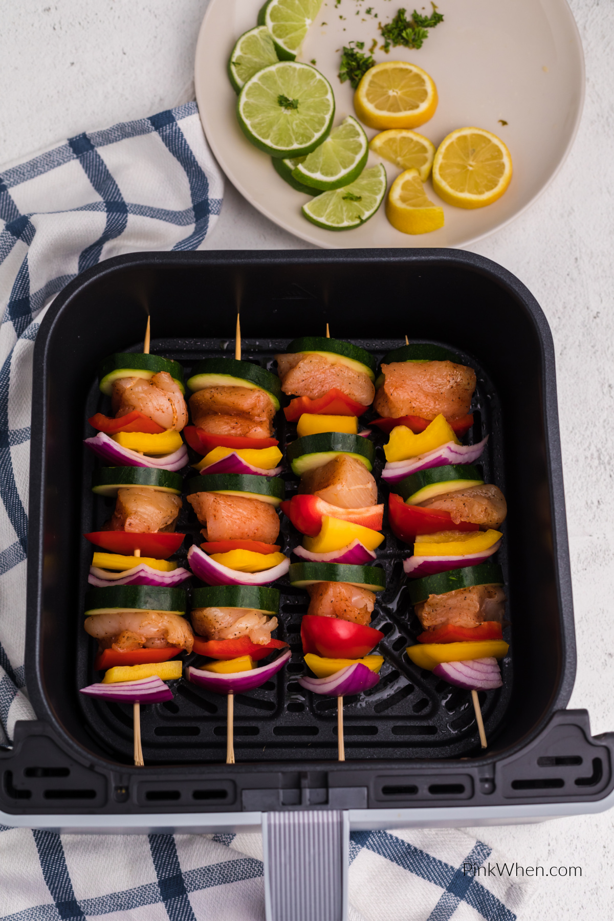 Chicken kabobs in air fryer basket ready to be cooked.