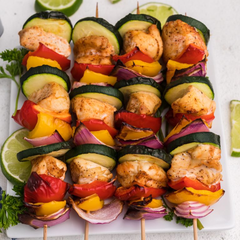Air Fryer Chicken Kabobs on a white plate with sliced limes.